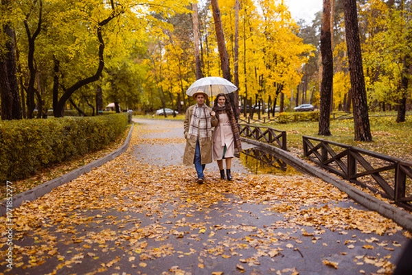 Obraz Charming couple enjoying a cozy moment outdoors in a city park during autumn. They share a joyful smile, conveying warmth and connection on a sunny day.