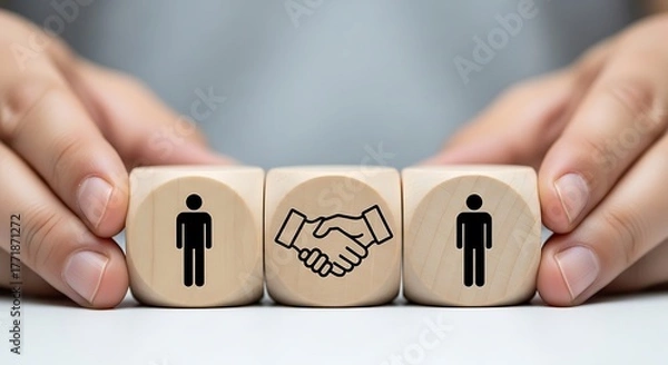 Fototapeta Two people shaking hands represented by icons on wooden blocks