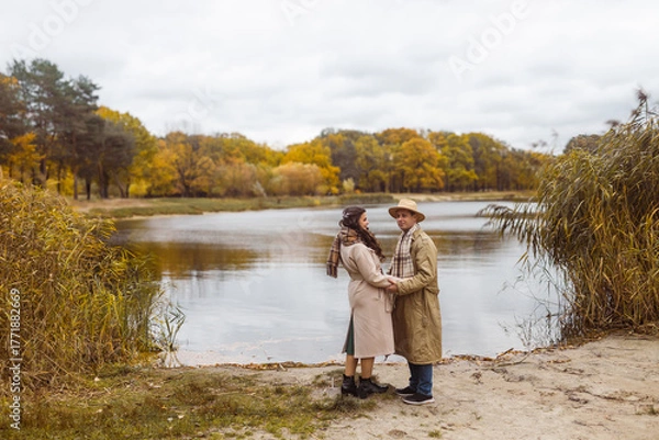 Obraz Charming couple enjoying a cozy moment outdoors in a city park during autumn. They share a joyful smile, conveying warmth and connection on a sunny day.