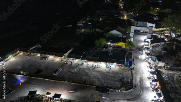 Fototapeta The atmosphere of Waingapu's Old Town to the Seaport seen from the air with a drone at night