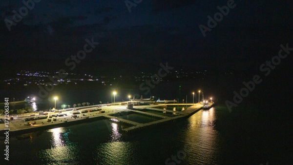 Fototapeta The atmosphere of Waingapu's Old Town to the Seaport seen from the air with a drone at night