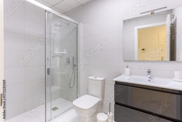 Obraz Modern bathroom with walk-in glass shower, toilet, and glossy vanity with mirror