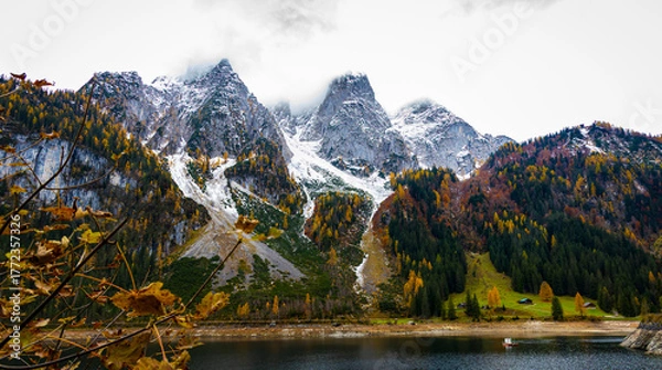 Fototapeta Autumn's First Snow Track Gosausee with Dachstein mountain summit and blue lake as idyllic colorful autumn scenery background