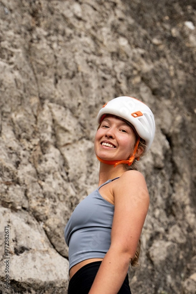 Obraz Positive woman rock climber resting after climb outdoors, athlete girl smiling with satisfaction and confidence in mountains
