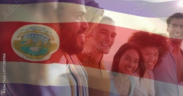 Fototapeta Standing six smiling friends wearing clothes outdoors at sunset, with Costa Rica flag crest overlay
