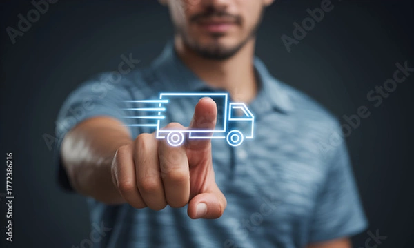 Fototapeta Man's finger activating futuristic glowing blue truck icon on dark background, symbolizing fast delivery and logistics technology for modern business solutions.