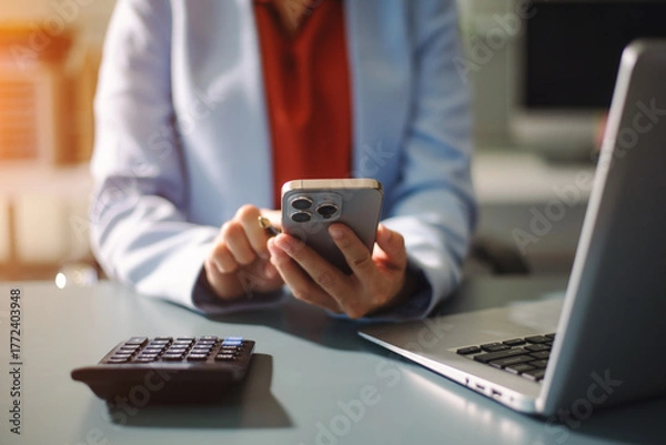 Fototapeta Businesswoman using a stylus with smart phone in office. Concept of smart technology, remote work