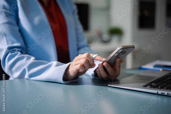Fototapeta Businesswoman using a stylus with smart phone in office. Concept of smart technology, remote work
