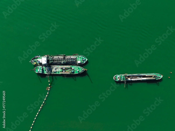 Fototapeta Plain teal green background of dredgers working.