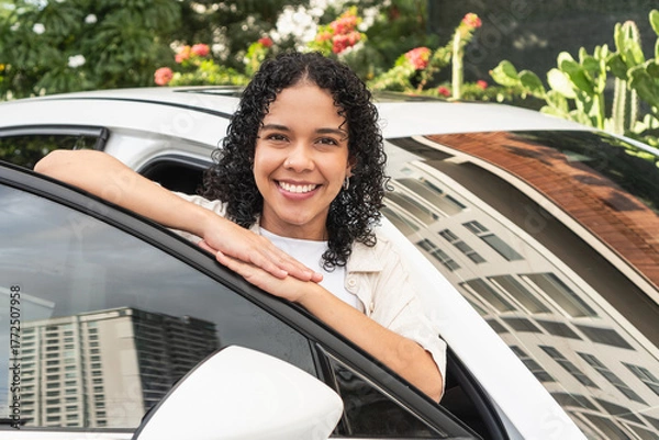 Fototapeta Happy woman smiling from new car window
