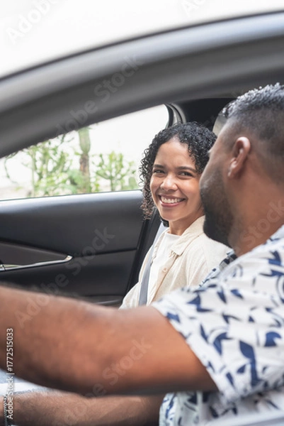 Fototapeta Happy couple enjoying road trip, smiling inside car