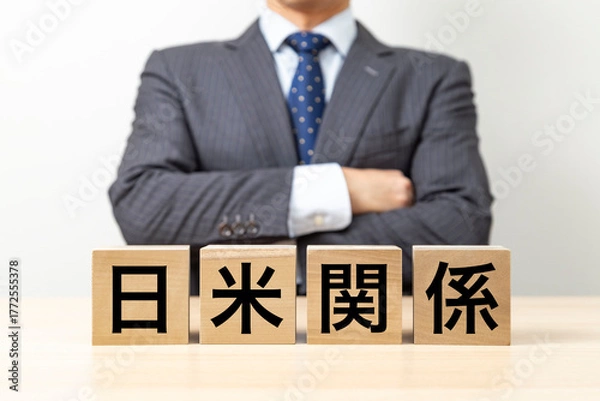 Fototapeta 「日米関係」と書かれたブロックと腕組みをするビジネスマン