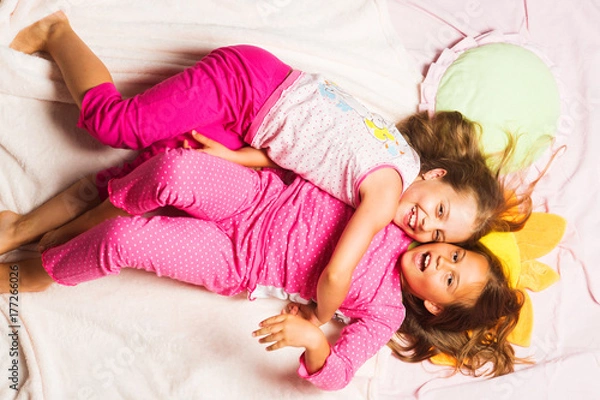 Fototapeta Kids in pink pajamas having fun. Children with smiling faces