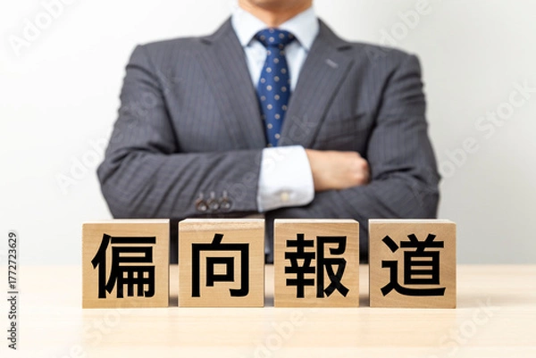 Obraz 「偏向報道」と書かれたブロックと腕組みをするビジネスマン