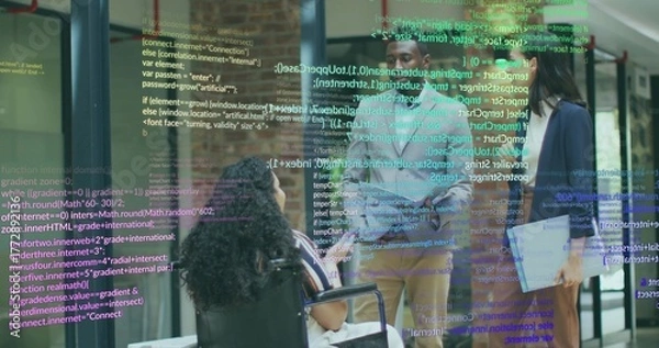 Obraz Collaborating team in blazers projecting code snippets in office hallway with laptop and wheelchair