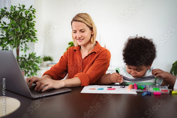 Fototapeta Mother working remotely while child drawing at home