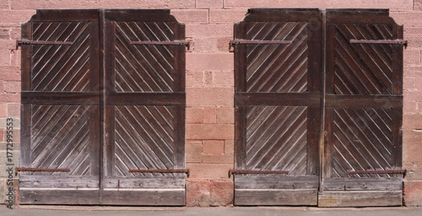 Obraz Zwei alte braune ländliche Holztore nebeneinander in einem Mauerwerk aus rotem Sandstein
