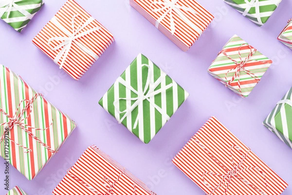 Fototapeta Many striped Christmas gift boxes on color background, top view