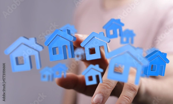 Fototapeta Person's hand with blue house icons floating, conceptualizing housing market, real estate investments, and home purchase. Innovative approach to