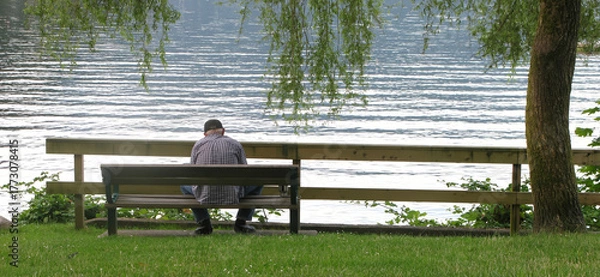 Obraz Time to Reflect - Man on park bench at water's edge