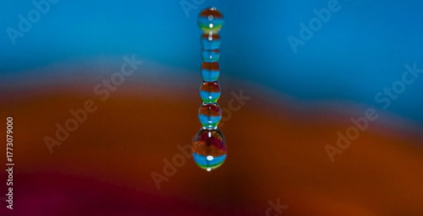 Fototapeta A series of water droplets are captured in mid-air,