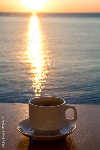 Obraz White Coffee cup in the morning time with sunrise path on the water.