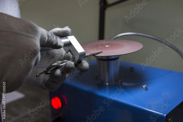 Obraz master man sharpens the machine scissors so they were sharp