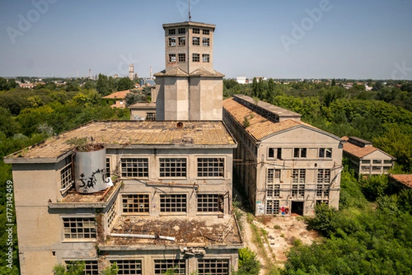 Fototapeta Abandoned distillery tower in Italy – circular industrial building with glass dome, steel beams, panoramic windows, decaying factory interior, urban exploration, post-industrial architecture