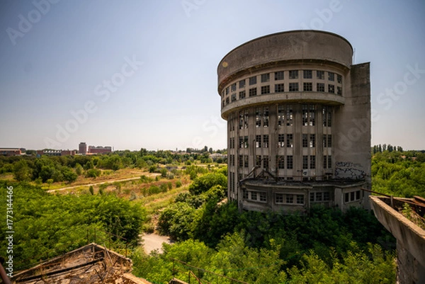 Fototapeta Abandoned distillery tower in Italy – circular industrial building with glass dome, steel beams, panoramic windows, decaying factory interior, urban exploration, post-industrial architecture