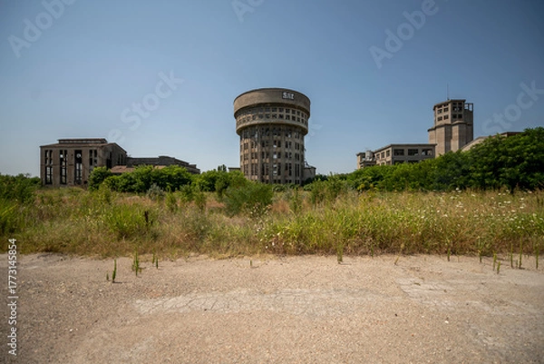Obraz Abandoned distillery tower in Italy – circular industrial building with glass dome, steel beams, panoramic windows, decaying factory interior, urban exploration, post-industrial architecture