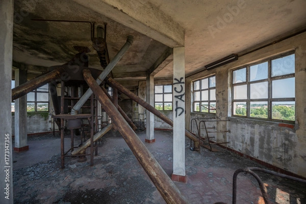 Fototapeta Abandoned distillery tower in Italy – circular industrial building with glass dome, steel beams, panoramic windows, decaying factory interior, urban exploration, post-industrial architecture
