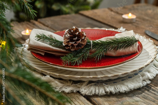 Fototapeta Festive Christmas table decor. Plates and napkin decorated pine cone and spruce twig
