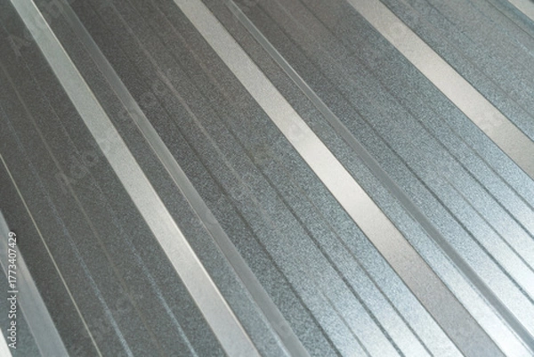 Fototapeta Close-up view of a new corrugated metal sheet with a shiny galvanized surface, perfect for roofing, wall cladding, or industrial background texture.