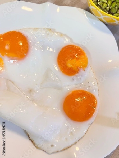 Fototapeta Three fried duck eggs on a plate.