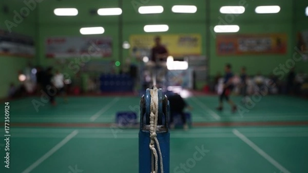 Fototapeta Badminton net straps attached to poles with badminton court in blur background