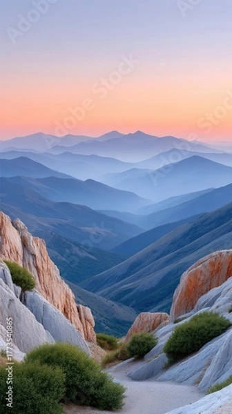 Fototapeta Serene Mountain Range Vista at Dawn with Hazy Blue Valleys and Soft Pink Sky Overlooking Rocky Outcrops and Greenery