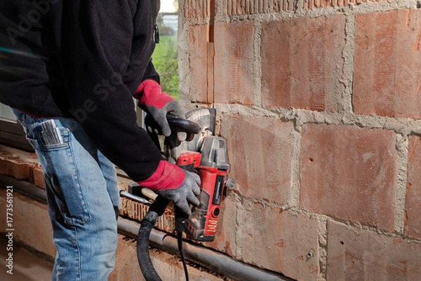 Obraz Construction Worker using a Wall Chaser to make Channels for Electric Installation