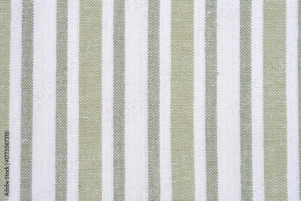Fototapeta A close-up full-frame shot shows a repeating pattern of vertical stripes in muted light green and white on a woven textile surface