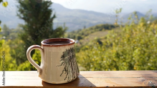 Fototapeta Handmade Ceramic Mug of Coffee Against a Sunny View