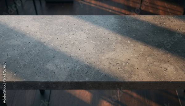 Fototapeta Close-up of a speckled concrete surface with dappled light.