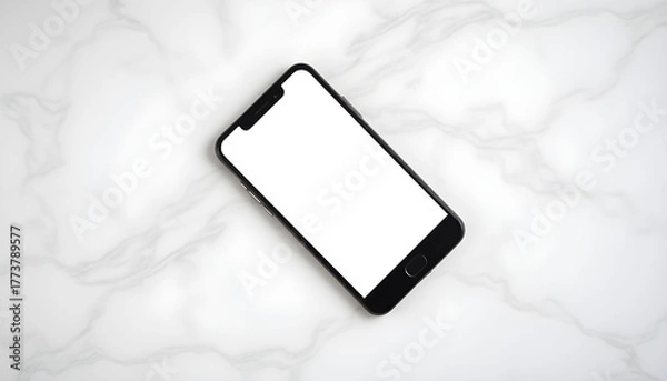 Fototapeta A black smartphone with a blank screen rests on a marble surface.