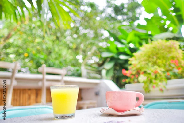 Obraz Very light breakfast with only an orange juice and a cup of coffee on a terrace outside in the famous neighborhood "el poblado" in Medellin, Colombia.