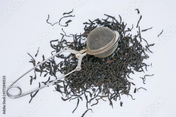 Fototapeta Loose Leaf Black Tea with Metal Tea Infuser on White Background
