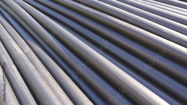 Obraz Row of HDPE pipes stack on the ground in construction site for underground water piping installation work