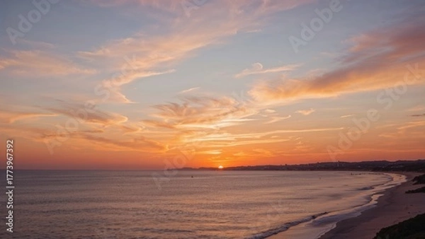Fototapeta Sunset over the ocean at a beach with a colorful sky and clouds.