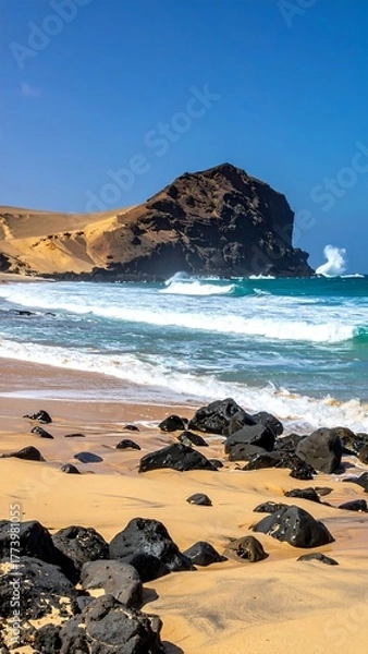 Obraz A bright beach day with large waves crashing and dark rocks on golden sand