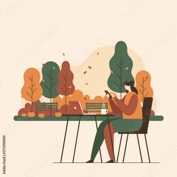 Fototapeta Digital nomad working in an autumn park with phone laptop and coffee