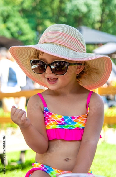 Fototapeta Child in a hat and sunglasses. Selective focus.