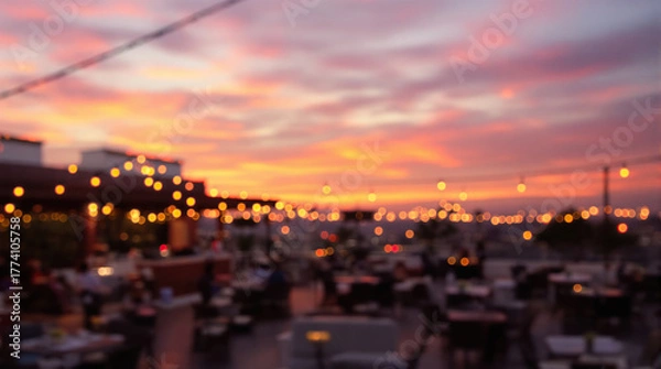 Fototapeta Rooftop bar with blurred bokeh lights and a vibrant sunset sky, creating a beautiful and atmospheric evening scene
