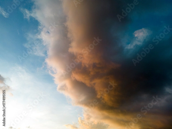 Fototapeta An aerial hyper lapse of colorful clouds at blue hour. Saturated colors and sun rays filtering through the cloud cover add to the beauty of the photo.